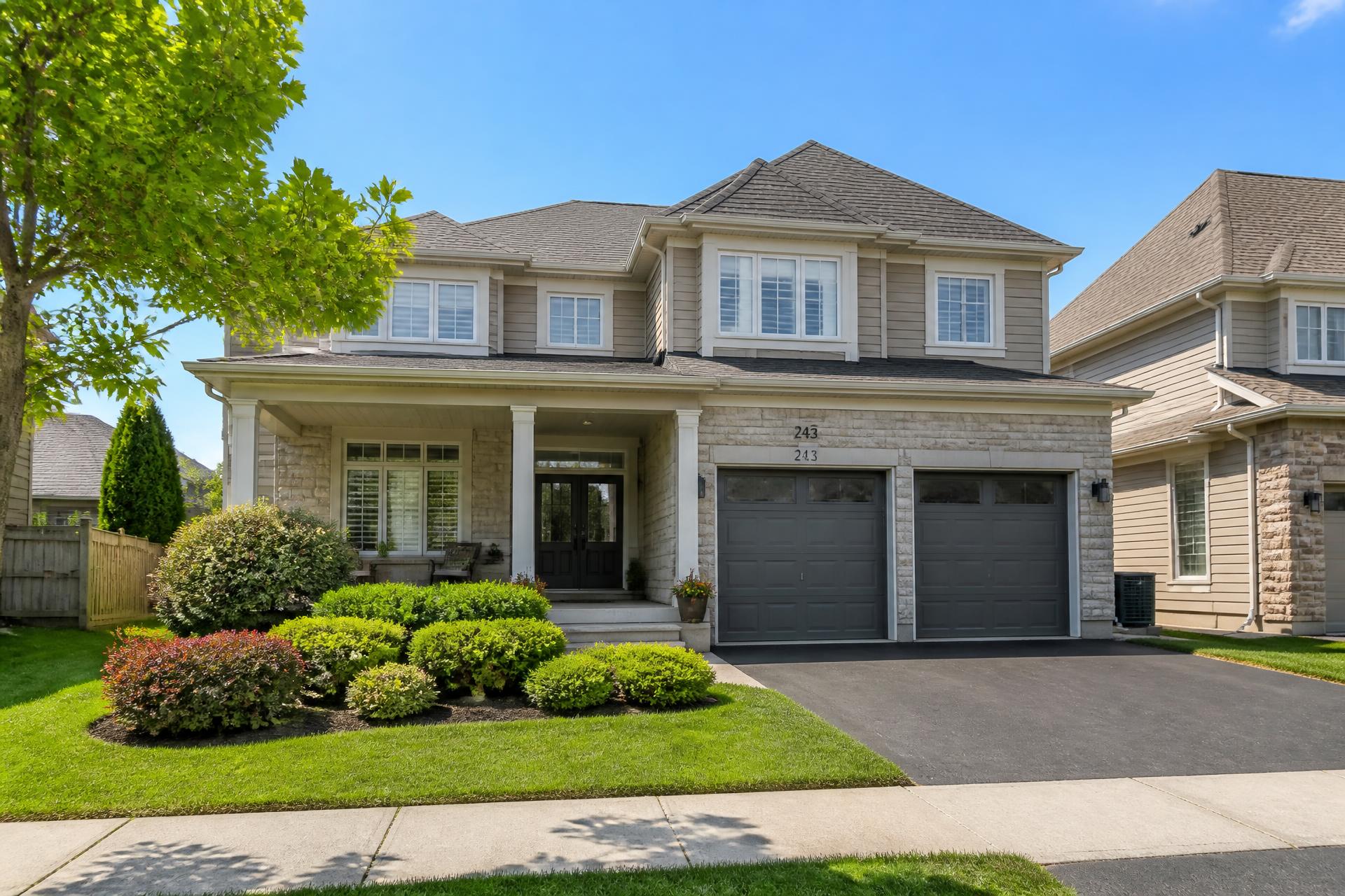 Contemporary suburban GTA family home with stone and horizontal siding on a bright summer day